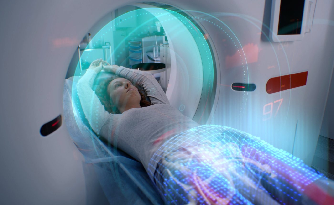 A patient lying on the table of a CT scanner as the scan begins