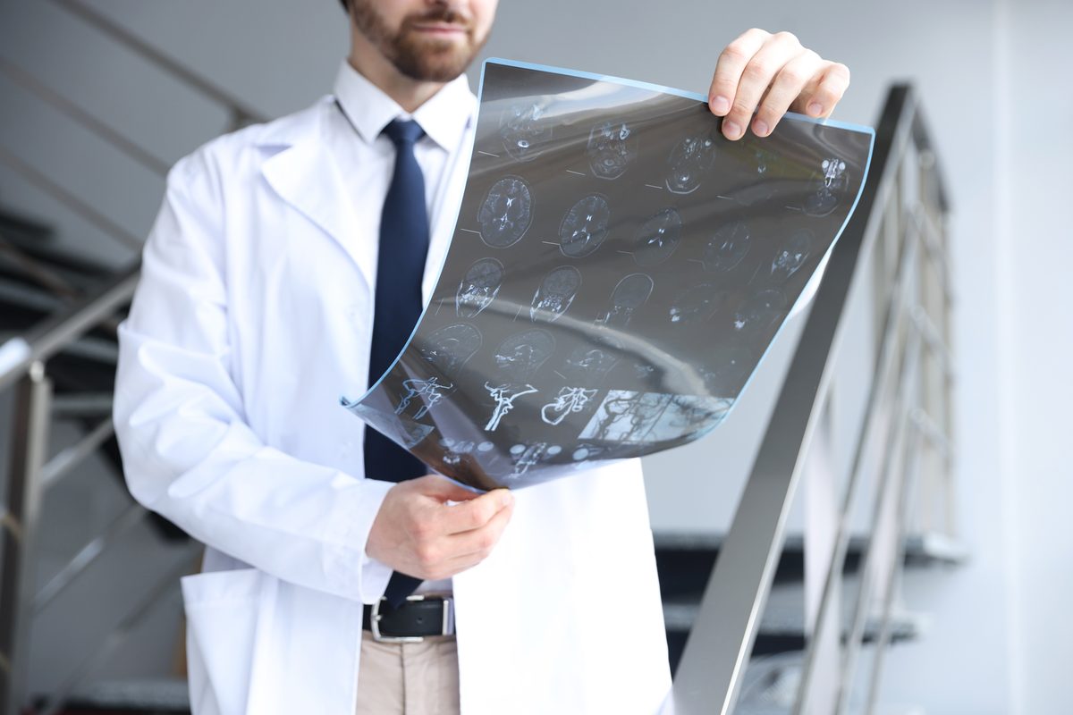 A doctor in a white coat examining scan images